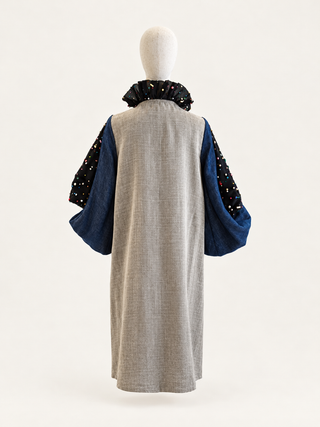 Back view of the Soulful taupe-grey linen top with deep blue layered sleeves and an embellished black ruffle collar.